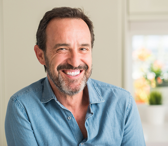 Smiling older man in a denim shirt