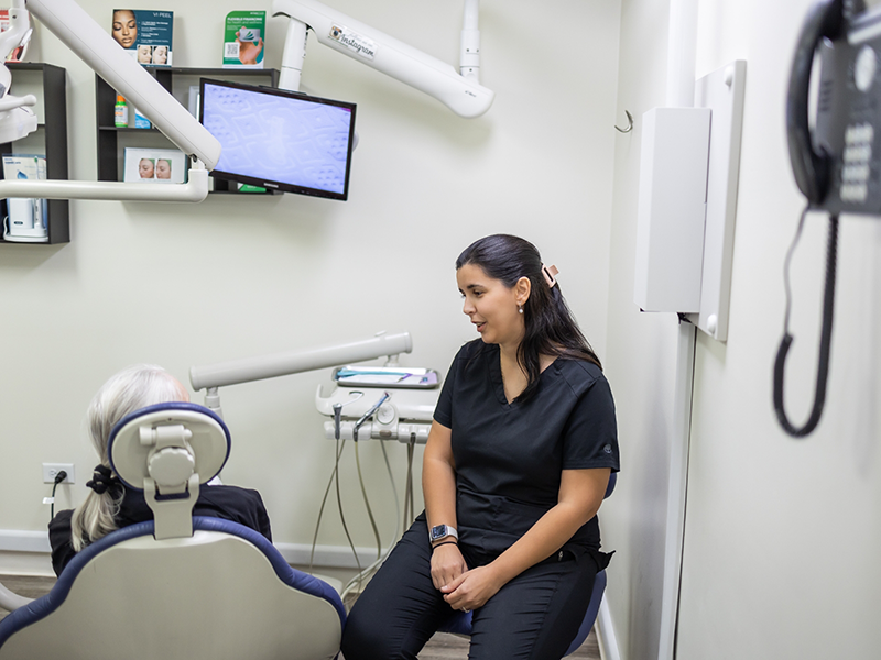 Dental team member talking to a patient in the treatment chair