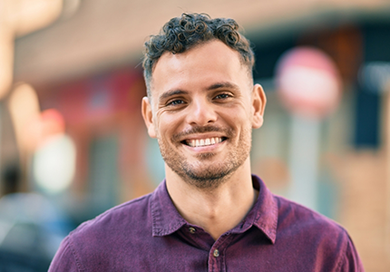 Smiling man with short curly brown hair