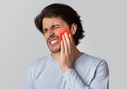 Man holding the side of his face in pain