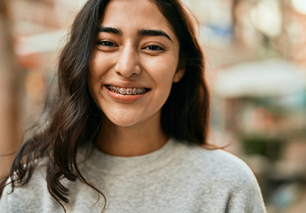 Smiling young woman with traditional braces