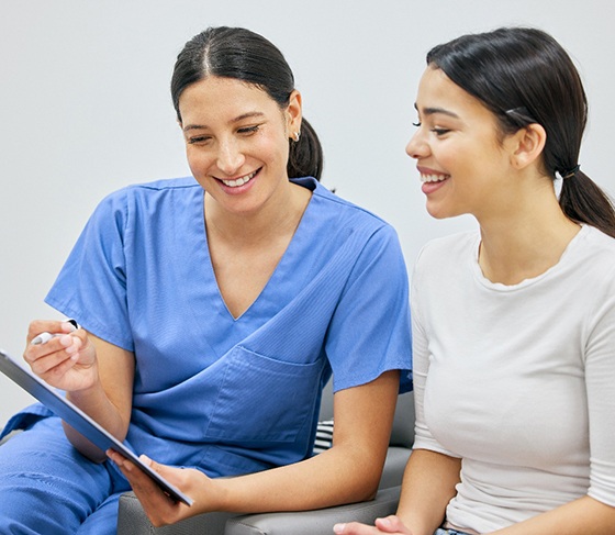 Dental staff member discussing veneer cost with patient