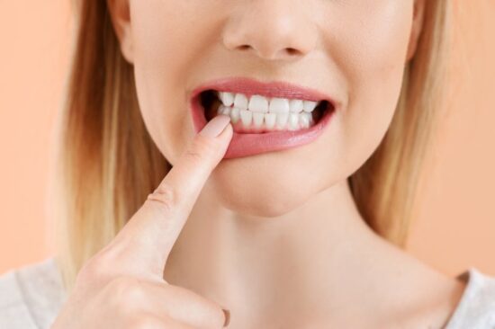 Woman pointing to teeth.