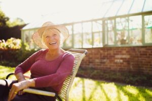 older woman sitting outside and smiling