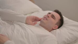 Man lying in bed with a toothache